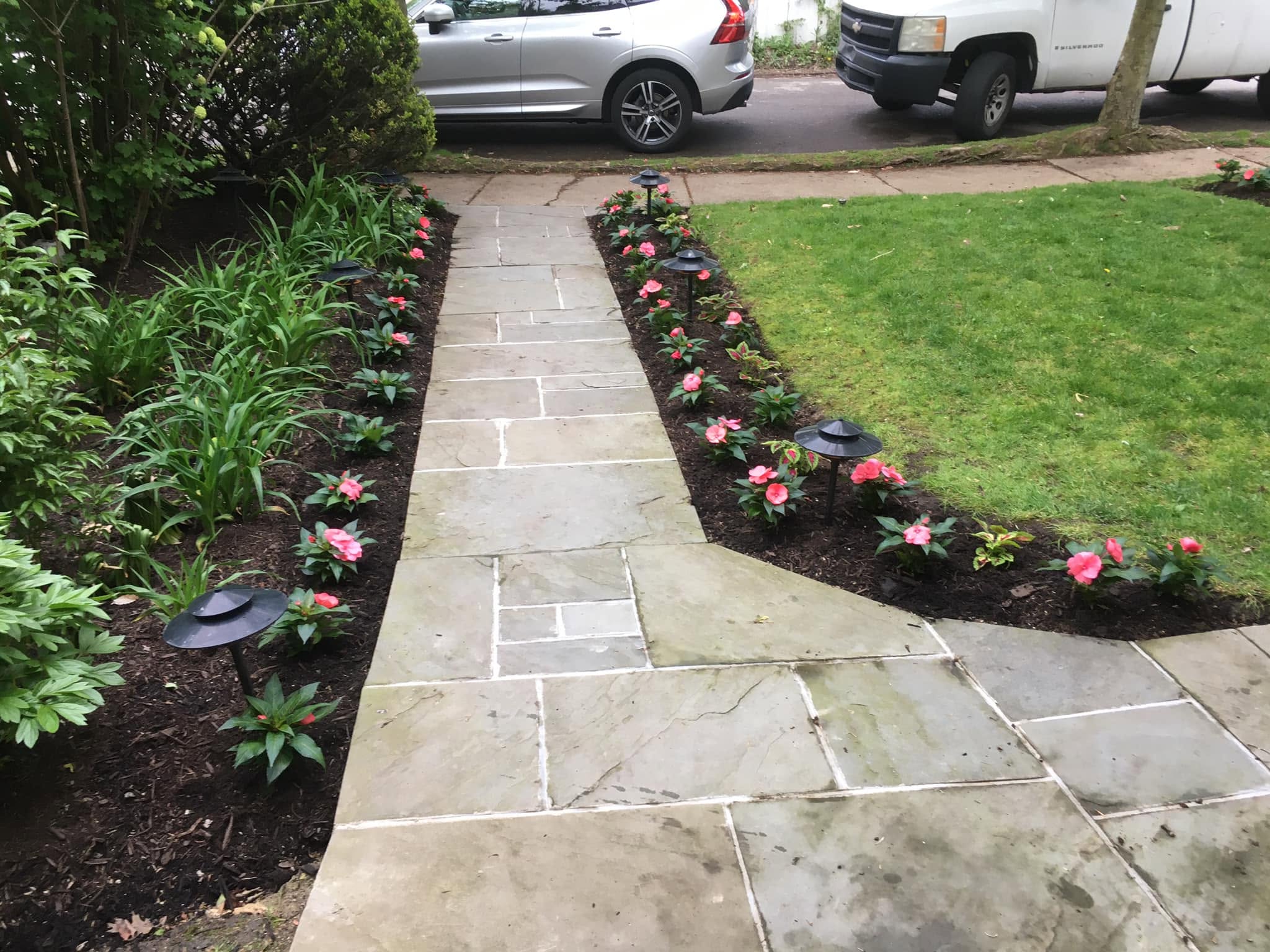 Real stone paver walkway lined with mulched flower beds, installed by Old Allegheny Landscaping